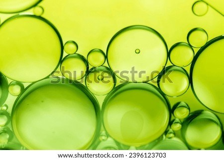 lemon drops of oil or serum texture background. Abstract lemon fluid with bubbles. Macro shot Royalty-Free Stock Photo #2396123703