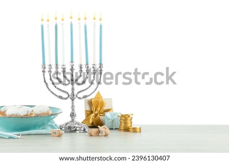 Hanukkah celebration. Composition with menorah, dreidels and donuts on table against white background