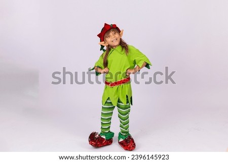 Funny little girl dressed as Santa's little elf. Little girl in elf outfit, playful