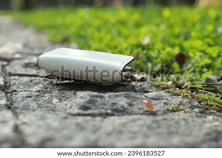 White leather purse on stone surface outdoors, closeup. Lost and found Royalty-Free Stock Photo #2396183527