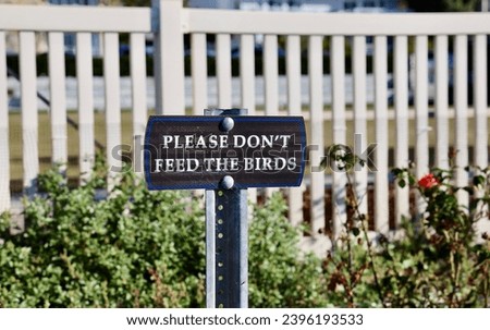 Public park with a sign asking visitors to not feed the birds