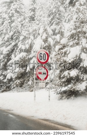 
Speed ​​limit, dangerous, slippery road. Road sign. Snowy road, snowy landscape. Winter picture.