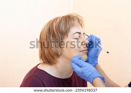 Cosmetologist doing microblading procedure - close up