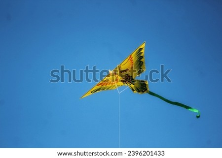 yellow kite floating in the sky