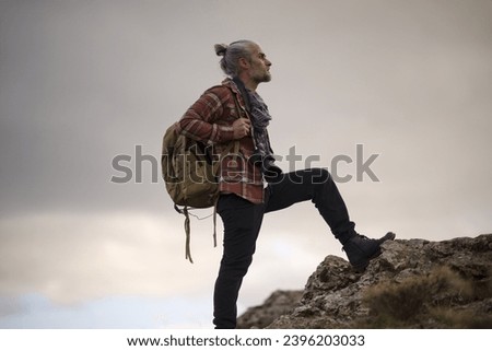man walking around hills and foothills in autumn and taking photographs