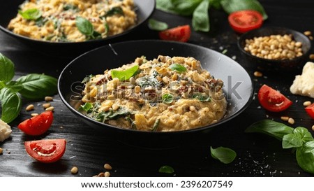 Creamy spaghetti squash pasta with parmesan cheese and sun dried tomato sauce served with pine nuts and basil Royalty-Free Stock Photo #2396207549