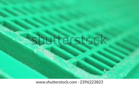 A Square Pattern on a Green Plastic Surface. A Vibrant Green Abstract Background