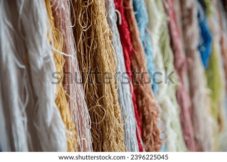 Colorful silk threads for weaving in a textile factory , Cotton color natural dyes handmade, old weaving loom and thread of yarn. 