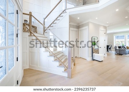 Interior foyer entry front door with hat rack coat hooks decor wood and tile flooring open door vaulted ceiling exposed brick wall welcome to a warm and comfortable family home Royalty-Free Stock Photo #2396235737