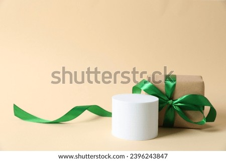 Bright gift near a white podium with copy space. Christmas or New Year celebration concept
