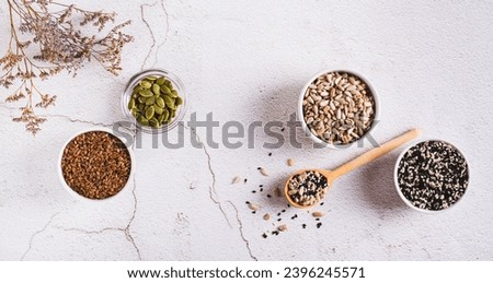 Pumpkin, flax, sesame and sunflover seeds cycling for hormone balance top view web banner Royalty-Free Stock Photo #2396245571