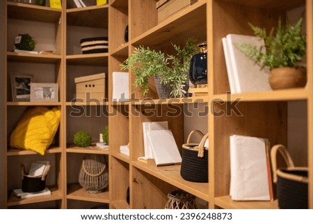 Open furniture shelves in living room, office, study are filled with various things. Storage system and organization. Order in house. Modern design. Proper organization of space. 