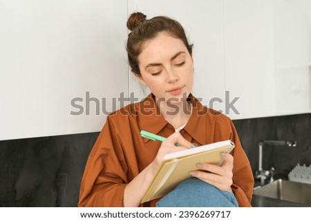 Portrait of woman drawing in notebook, writing down her thoughts on paper.