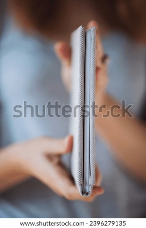 Female hands holding photo book for wedding album. Looking in photo book, family album. Detail of opened photo book. Pages of photoalbum shallow depth of field. View of book pages. openwork stamping