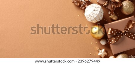 Christmas banner design with space for text. Flat lay composition with gift box, cozy decorations, ball ornaments on brown background
