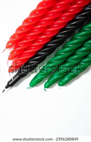 Happy Kwanzaa concept. African-American holiday. Seven candles - red, black and green. African heritage symbol on a white background. Vertical photo