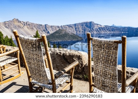 Rocking Chairs at Crater Lake Lodge with Wizard Island and crater rim in background.