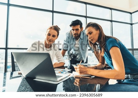 Group of diverse profession business people pointing at laptop displayed idea. Portrait of business team show marketing strategy present by laptop with statistic document scatter on table. Tracery. Royalty-Free Stock Photo #2396305689