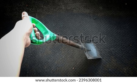 photo of a hand holding a shovel