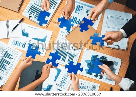 Multiethnic business people holding jigsaw pieces and merge them together as effective solution solving teamwork, shared vision and common goal combining diverse talent. Habiliment Royalty-Free Stock Photo #2396310059