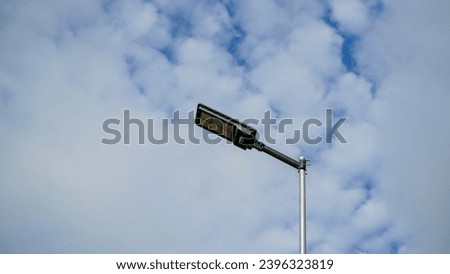 Low-angle view of modern long street led light pole under beautiful cloudy blue sky atmosphere background.