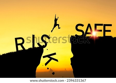 Silhouette of man jumping from risk cliff to safe cliff on orange sky for risk assess management to get safe zone concept. Royalty-Free Stock Photo #2396331367