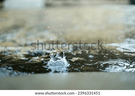 Raindrops hitting puddles on a rainy day. 