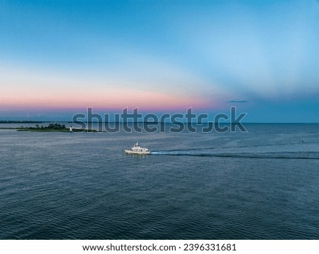 Yacht entering harbor with lighthouse in background Black Rock Connecticut Royalty-Free Stock Photo #2396331681