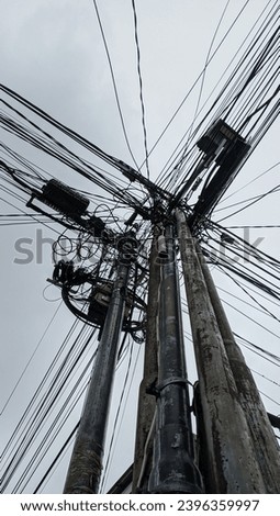 Low Angle View of Street Lamp With Large Number of Wires Against Blue Sky photo 