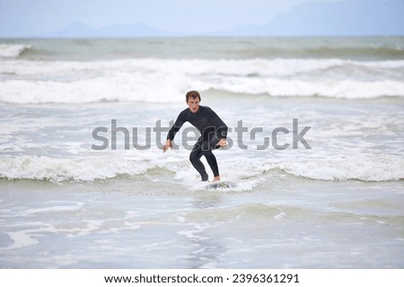 Surfer man, waves and board with balance, fitness and training for health, wellness and freedom in summer. Person, surfing and outdoor for sports, exercise and adventure at sea, ocean and sunshine
