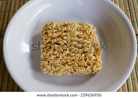 Instant noodles in white dish on wood background