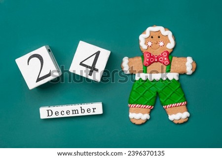 Christmas Gingerbread man, wooden calendar date 24 December isolated on green background Concept of Xmas preparation, atmosphere Wishes card Hand made wreath Flat lay Mock up Royalty-Free Stock Photo #2396370135