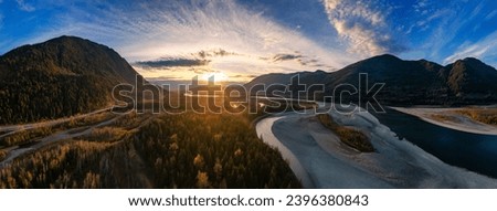 Scenic River in the Valley, surrounded by Mountains. Sunset, Fall Season. Aerial Landscape. Fraser Valley, British Columbia Canada. Panorama