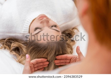 Healer performing by lightly touched set of 32 points of access bars on woman head, stimulating positive change thoughts and emotions. Alternative medicine. High quality photo