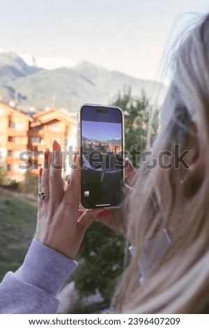 A young girl takes a photo or video on her mobile phone.