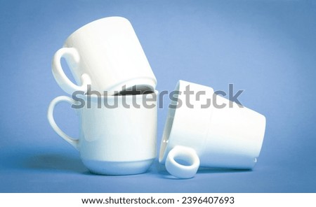 White coffee cups isolated on a solid blue background