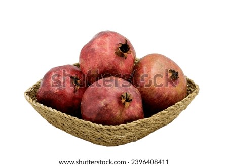 Four pomes of the pomegranate (Punica granatum) in a basket plate Royalty-Free Stock Photo #2396408411