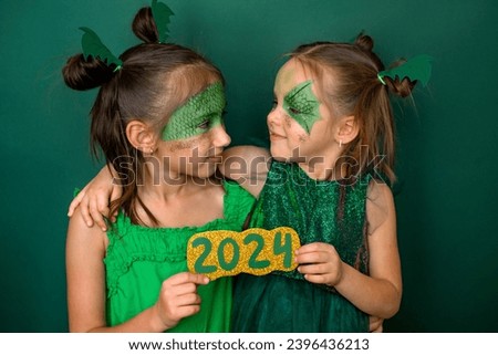 Children with painted faces hold the number 2024 on New Year's Eve. The made-up faces of children in the guise of a dragon are a symbol of the new year
