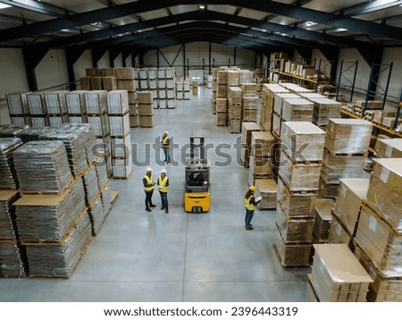 Top view of warehouse workers in warehouse. Team of warehouse workers preparing products for shipment, checking delivery, stock in warehouse.