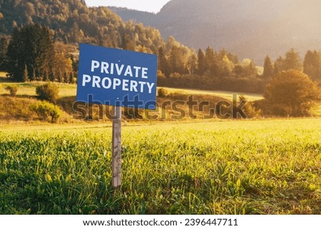 Private property information signboard in countryside meadow landscape, selective focus