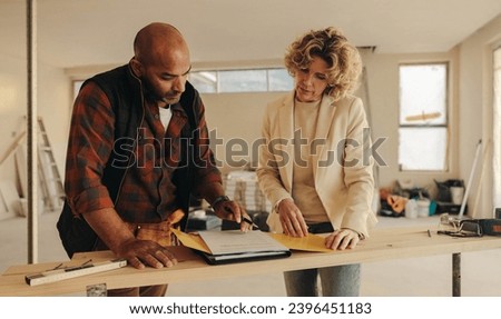 Mature contractor and homeowner signing a contract indoors for a home renovation project. They demonstrate professionalism and dedication to their work, ensuring a successful remodelling experience. Royalty-Free Stock Photo #2396451183