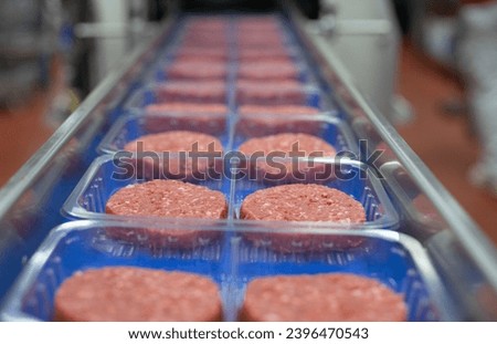 Row of hamburgers ready to be packaged