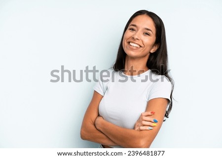hispanic pretty woman laughing happily with arms crossed, with a relaxed, positive and satisfied pose