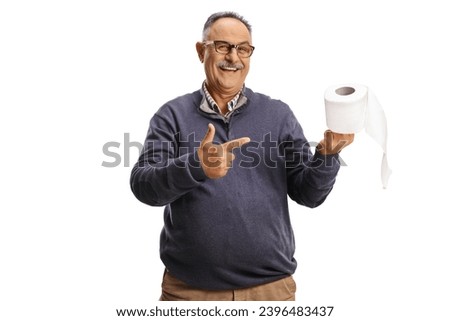 Smiling mature man holding a toilet paper roll and pointing isolated on white background