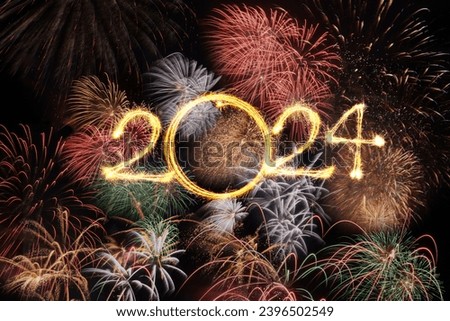 Happy new year 2024 text written with Sparkle fireworks in celebration with fireworks spakling on night sky background