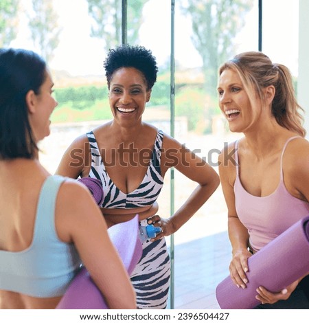 Three Mature Female Friends In Fitness Clothing Meeting At Gym Or Yoga Class Royalty-Free Stock Photo #2396504427