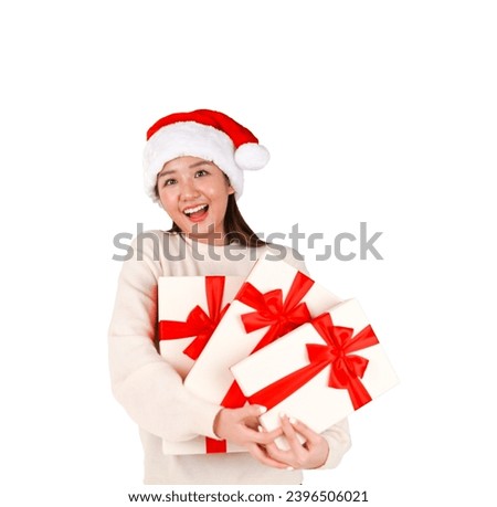 Happy young asian woman holding gifts with red ribbons while wearing a Christmas hat against a white background