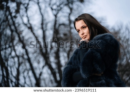 A Stylish Woman in a Fur Coat Posing Gracefully for a Fashionable Picture. A woman in a fur coat posing for a picture