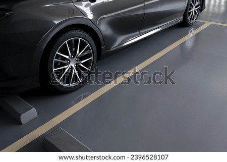 modern car in parking lot, anti slip coating floor for safety, car parked in the right position in modern building carpark area, image with copy space for banner background, diagonal composition