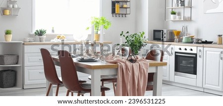 Served dining table in modern kitchen Royalty-Free Stock Photo #2396531225
